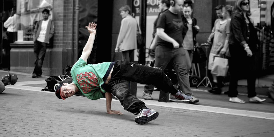 A young man breakdancing in the street