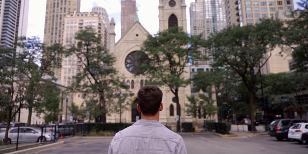 Image of a young man looking at a church