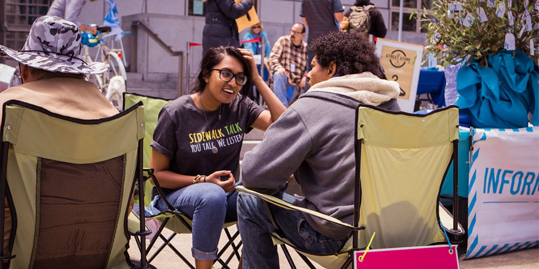 Two people sitting in chairs talking