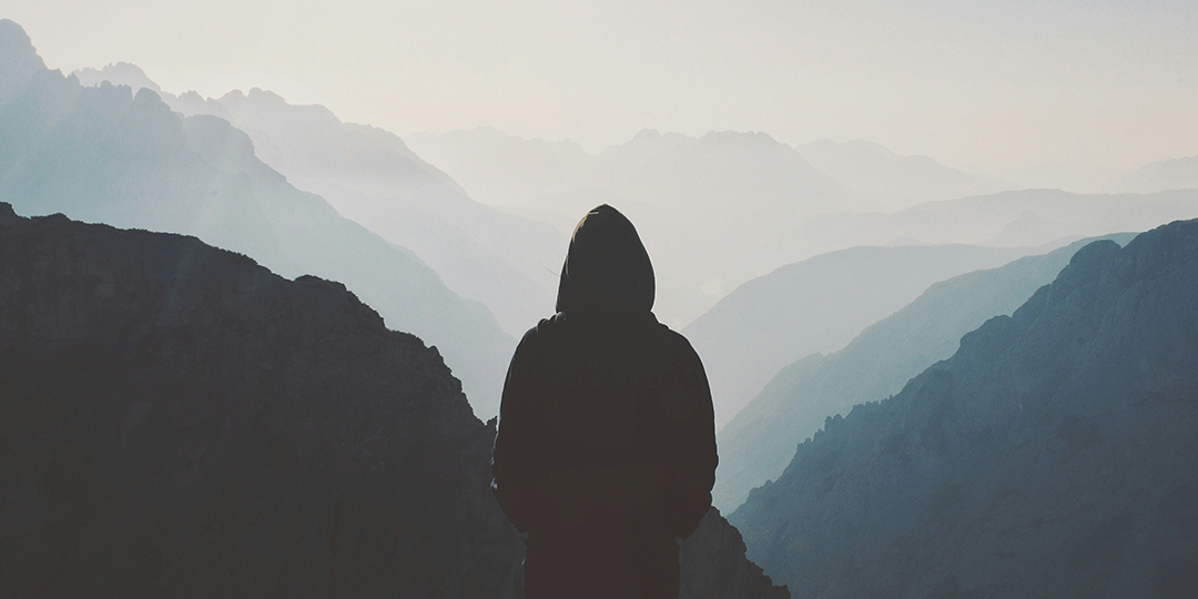 Image of a person looking out over misty mountains