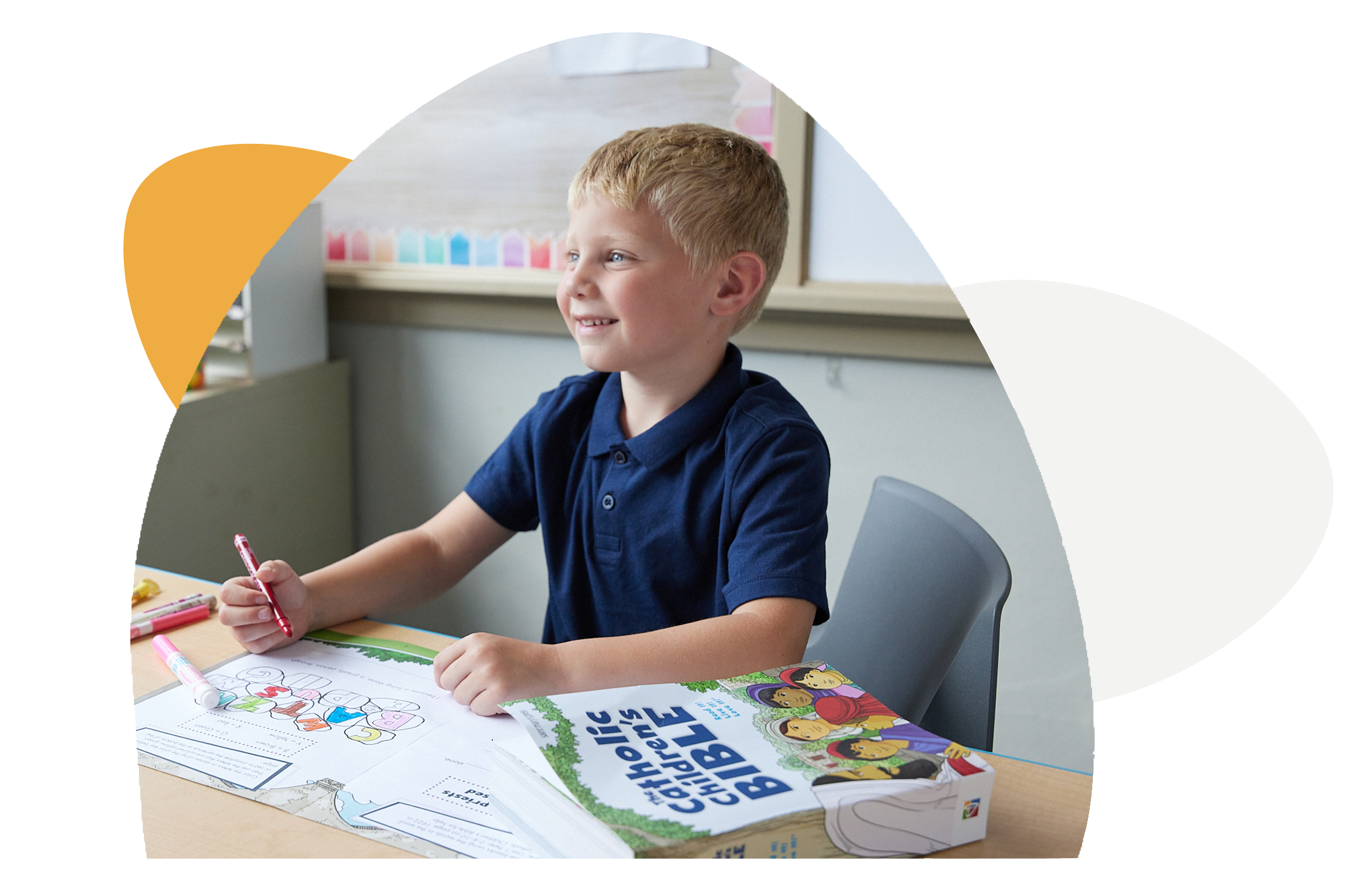 young boy sitting at a table with Discover! worksheets and The Catholic Children’s Bible