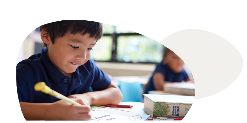 Boy at a desk writing on a Discover! worksheet